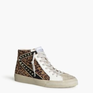 Zapatilla alta con estampado de leopardo en los paneles laterales y parte trasera, con detalles de tachuelas en un diseño en forma de "V" negra. La puntera es beige y tiene cordones blancos.